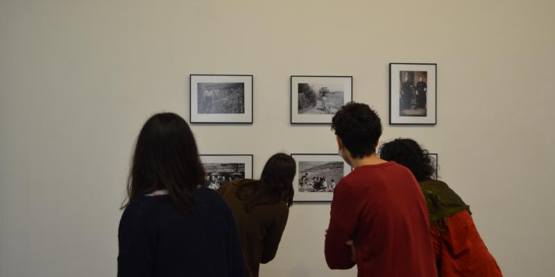 Visitantes observan unha das fotografías de "Entre amigos" exposta no primeiro andar do Claustro do Museo)